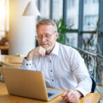 Man analyzing PPC strategies for orthopedic practices on a laptop, emphasizing Google Ads for digital marketing success in 2025.