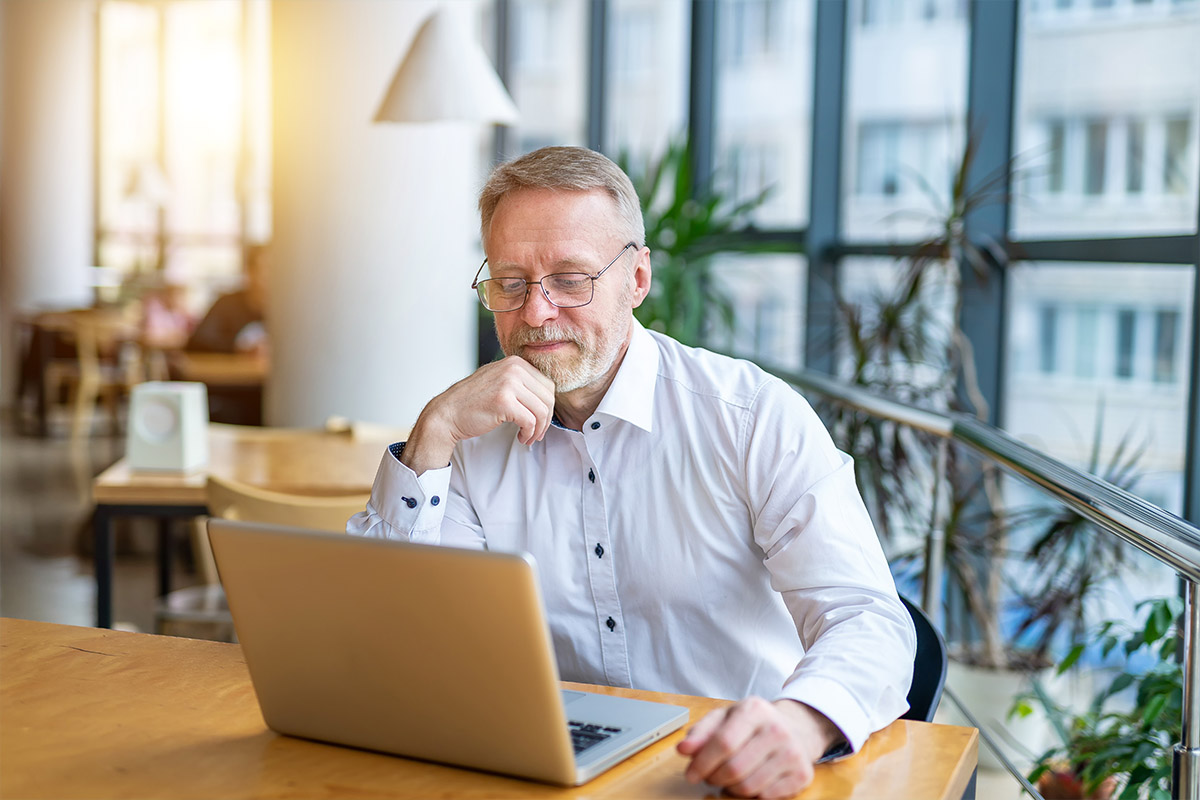 Man analyzing PPC strategies for orthopedic practices on a laptop, emphasizing Google Ads for digital marketing success in 2025.